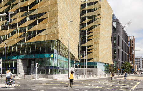 People walking and cycling beside Central Bank of Ireland building