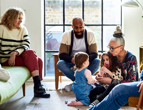 Group of adults and children sitting down and talking