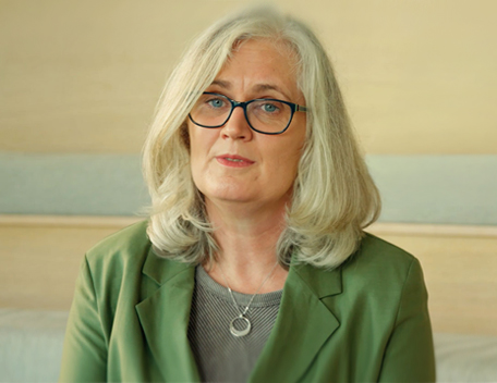 Blonde haired woman with a green jacket